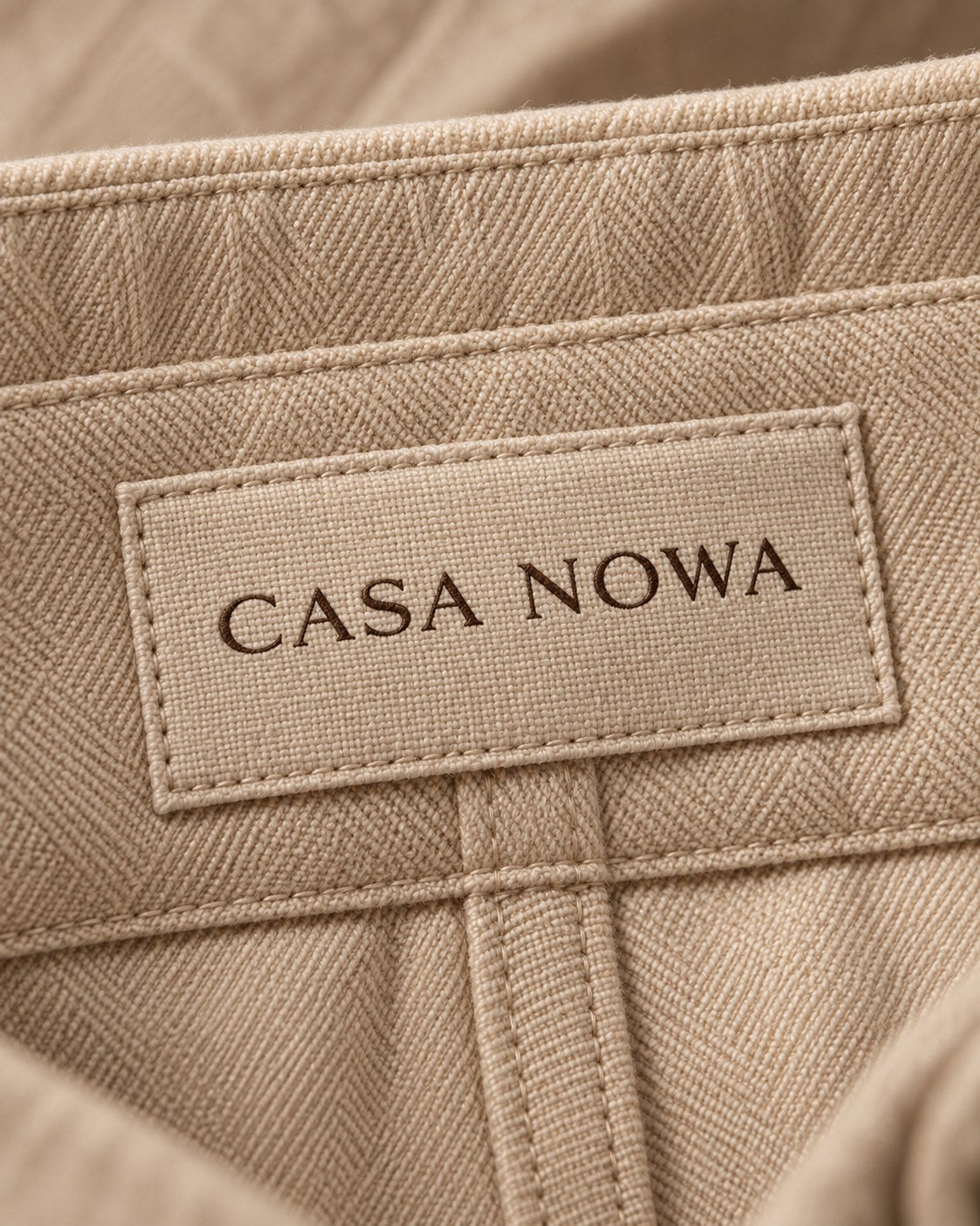 Macro: eticheta țesută CASA NOWA pe talie